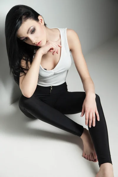 Černovlasá modelka na podlahové Studio — Stock fotografie