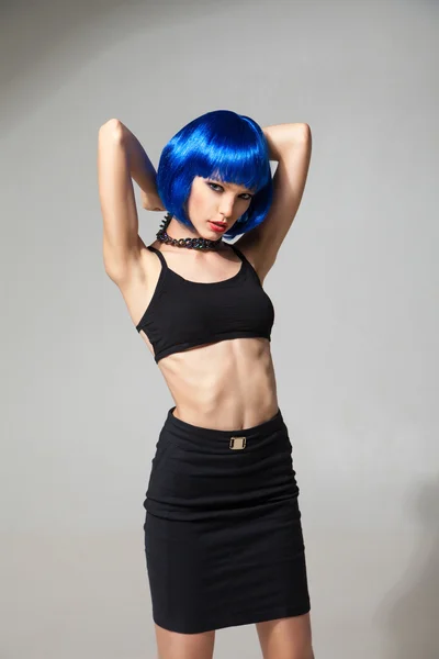 Portrait de fille mince en perruque bleue avec les bras levés — Photo