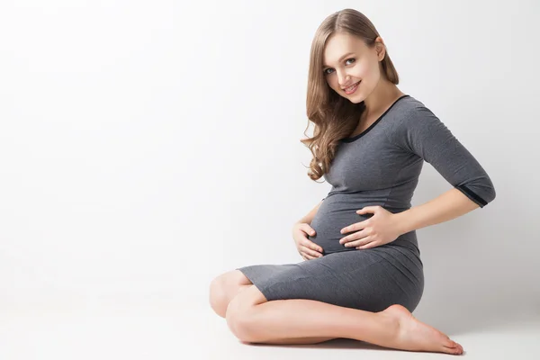 Futura mãe feliz sentada em estúdio — Fotografia de Stock