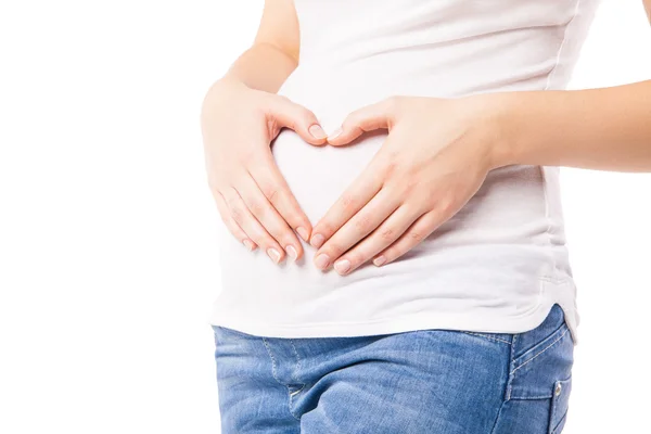 Close-up of pregnant woman embracing belly with heart shape — Stock Photo, Image