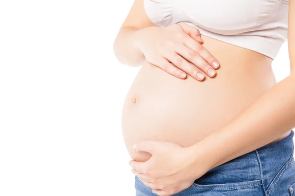 Oigenkännlig gravid kvinna omfamnar hennes mage — Stockfoto