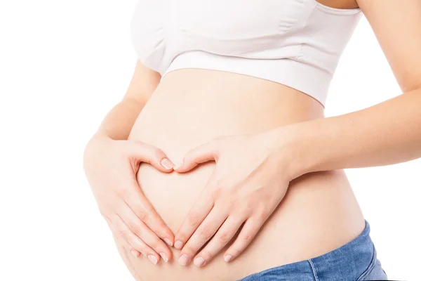 Nahaufnahme einer Frau, die ihren schwangeren Bauch umarmt — Stockfoto
