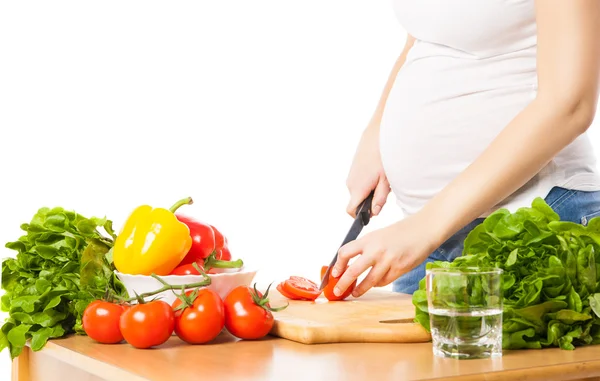 Close-up of pregnant woman cutting tomato — Stock Photo, Image