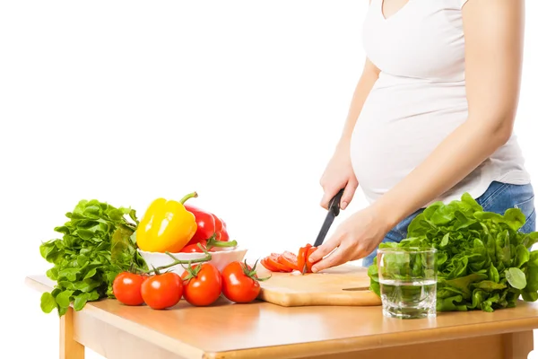 Close-up of pregnant woman cutting tomato — Stock Photo, Image