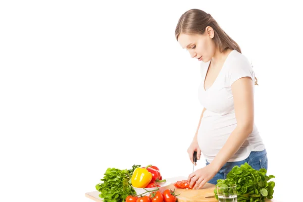 Vista laterale della donna incinta che cucina l'insalata — Foto Stock