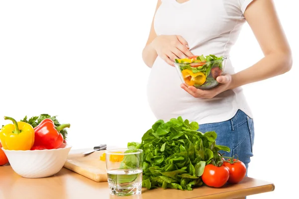 Крупный план беременной женщины, держащей миску со свежими овощами — стоковое фото