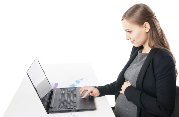Widok z boku uśmiechający się kobieta w ciąży na pulpit pracy na laptopie — Zdjęcie stockowe