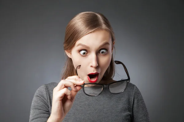 Mujer sorprendida con labios rojos mirando sus gafas — Foto de Stock