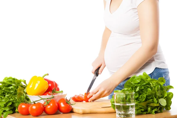 Close-up of pregnant woman cutting tomato Stock Photo