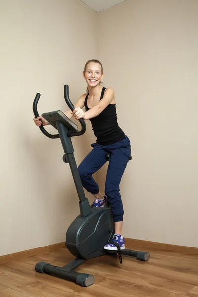 Cheerful teen girl cycling on home bike — Stock Photo, Image