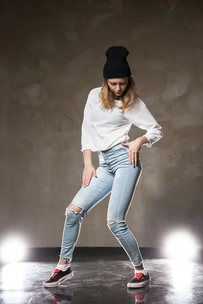 Young dancer in hat posing against of lights — Stock Photo, Image