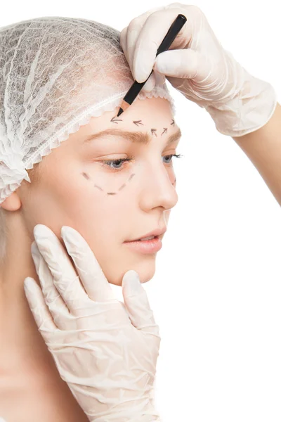 Plastic surgeon drawing outlines on womans face — Stock Photo, Image