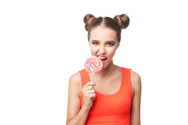 Brunette meisje met broodjes bijten lollipop — Stockfoto