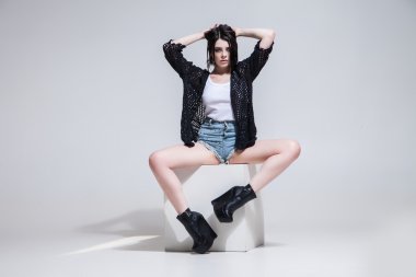 Güzel kadın beyaz küp üzerinde poz