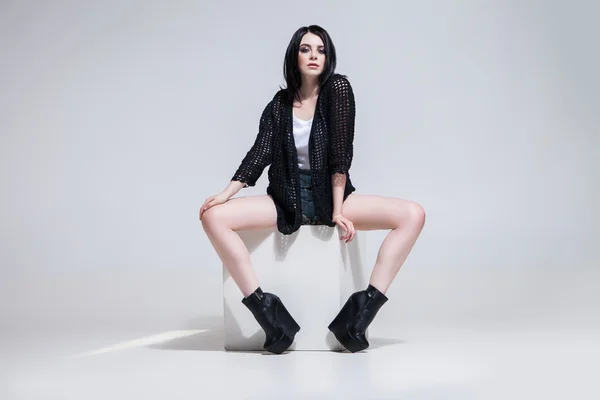 Beautiful woman posing on white cube — Stock Photo, Image