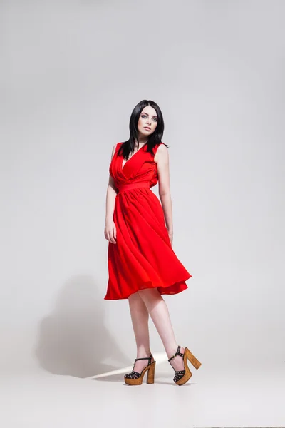 Siyah saçlı model Kırmızı elbiseli stüdyo çekim — Stok fotoğraf