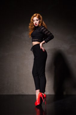 Kızıl saçlı kadın karşı ışık siyah duvar poz