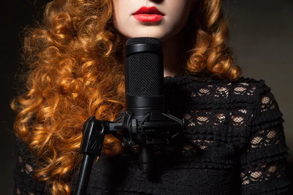 Close-up of curly-haired woman with mic — Stock Photo, Image