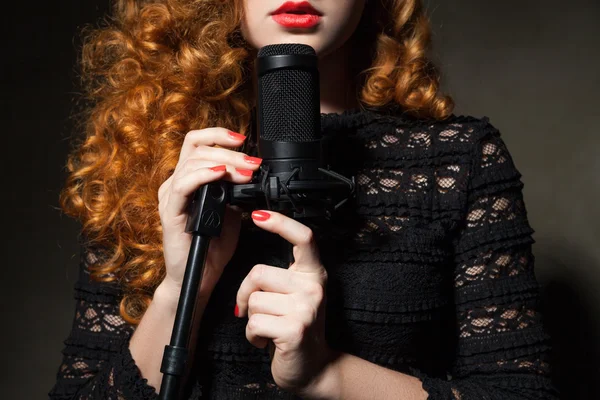 Närbild av curly-haired kvinna med mic — Stockfoto