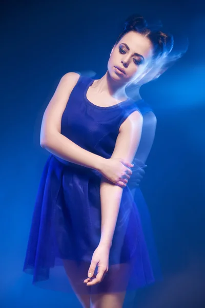 Attraente giovane donna in abito blu con acconciatura e trucco — Foto Stock