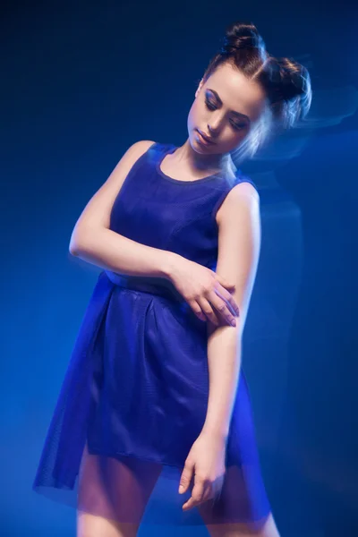 Attraente giovane donna in abito blu con acconciatura e trucco — Foto Stock
