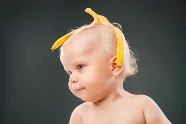 Bebê com casca de banana na cabeça — Fotografia de Stock