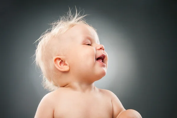 Sonriente bebé con el pelo desordenado mirando hacia otro lado —  Fotos de Stock