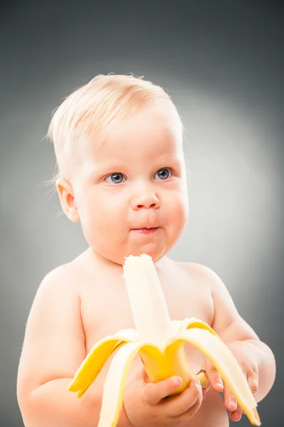 Porträtt av söt baby innehav uncorked banan — Stockfoto