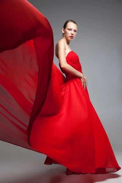 Menina loira jovem em vestido vermelho com saia voadora — Fotografia de Stock