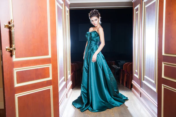 Elegante ragazza in bel vestito a piedi attraverso le porte — Foto Stock