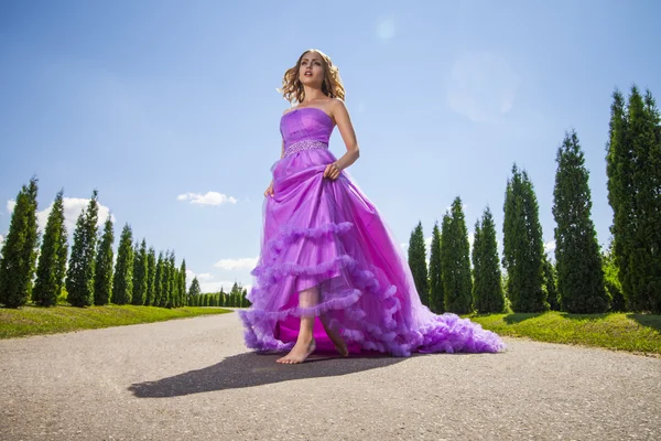 Blond kvinna i vacker rosa klänning på gränden — Stockfoto