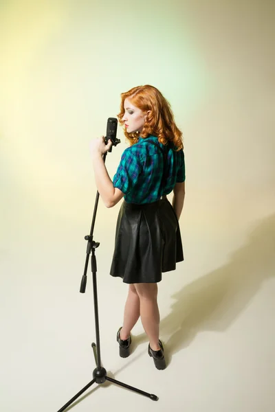Porträt einer stilvollen schönen Sängerin, die am Mikrofon singt — Stockfoto