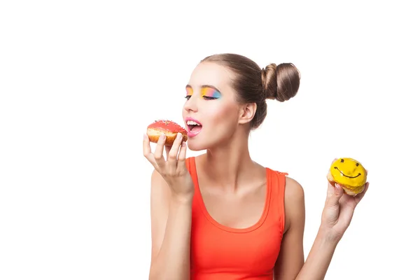 Studio shot of young brunette biting donut — Stock Photo, Image