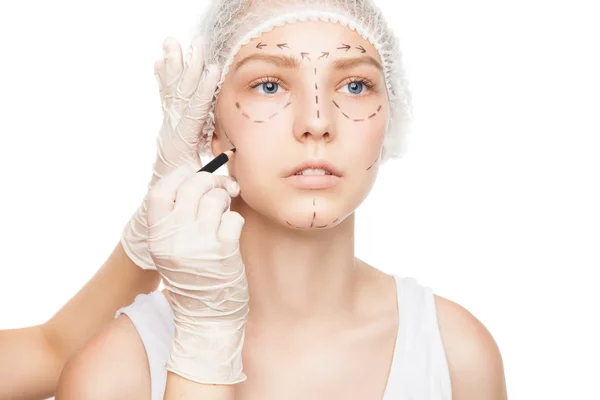 Hands in gloves painting outlines on girls face — Stock Photo, Image