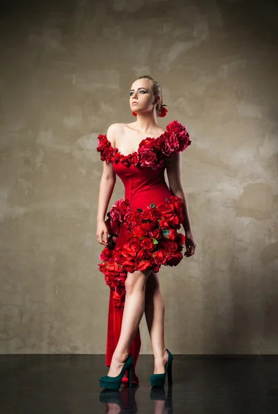 Mooie blonde model in rode bloemen jurk — Stockfoto