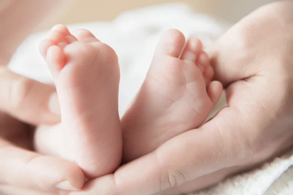 Rodzic trzyma nogi noworodka babys — Zdjęcie stockowe