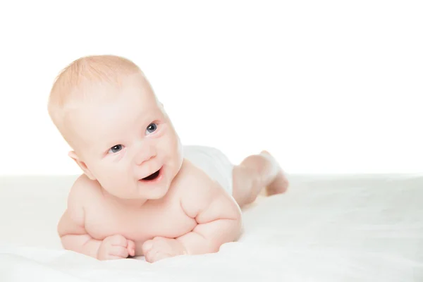 Little boy lying on stomach and smiling Stock Photo