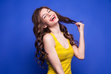 Saçlarını çekerek sarı elbiseli neşeli modeli