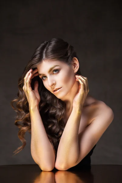 Young model with wavy hair. Golden tint on eyebrows and hands — Stock Photo, Image