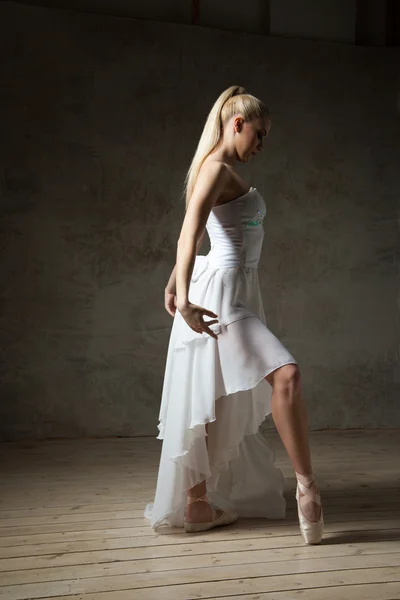 Vue latérale de l'élégante ballerine posant en blanc en pointes — Photo