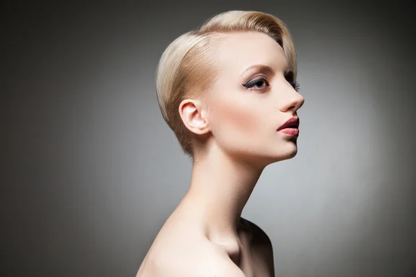 Studio shot di giovane modella bionda con acconciatura distogliendo lo sguardo — Foto Stock