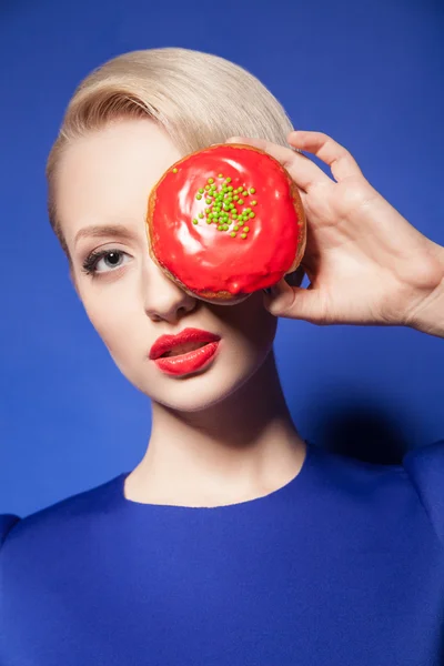 Primer plano del modelo de pelo rubio con el ojo cubierto de rosquilla roja —  Fotos de Stock