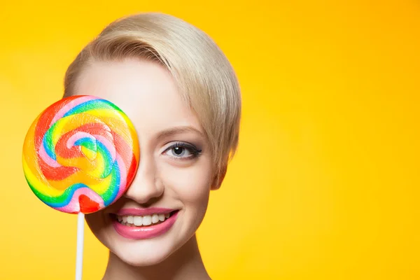 Vrolijke blondie met lollipop die betrekking hebben op ogen — Stockfoto