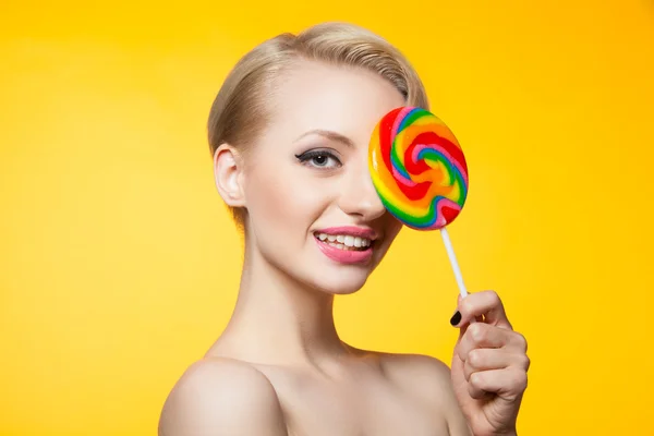 Model voor oog met lollipop en lachend op camera — Stockfoto