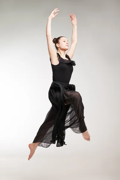 Giovane ballerina che indossa un vestito nero trasparente che salta — Foto Stock