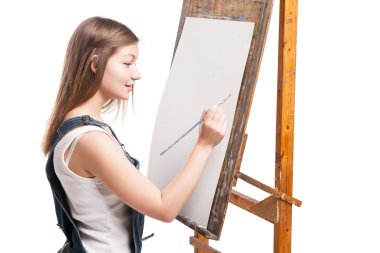 boya fırçası konumu itibariyle şövale olan genç gülümseyen kadın ressam