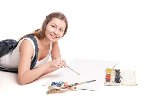 Jeune femme gît joyeusement sur le dessin au sol dans son bloc-notes — Photo