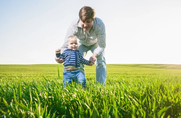 Unga far och hans son ha kul, spela på gröna fält — Stockfoto