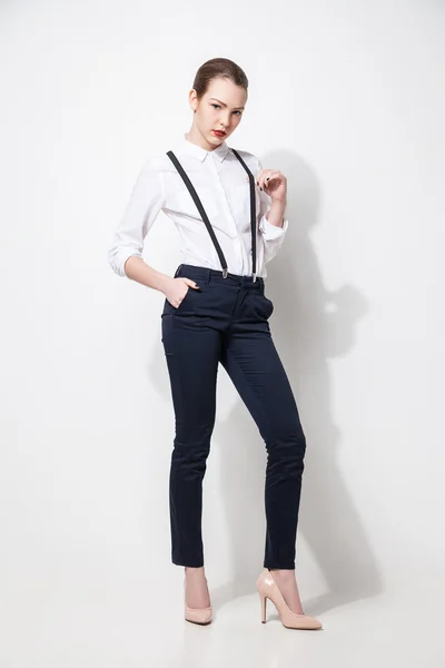Modemodel in schwarzer Hose und Top posiert über weißem Stoff — Stockfoto