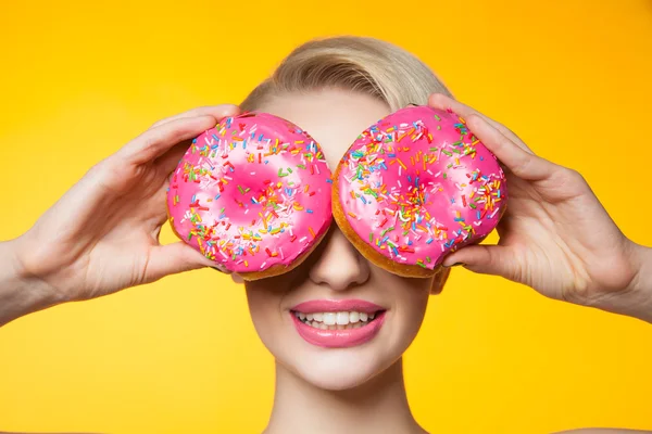 Korthaar model voor ogen achter twee roze donuts — Stockfoto